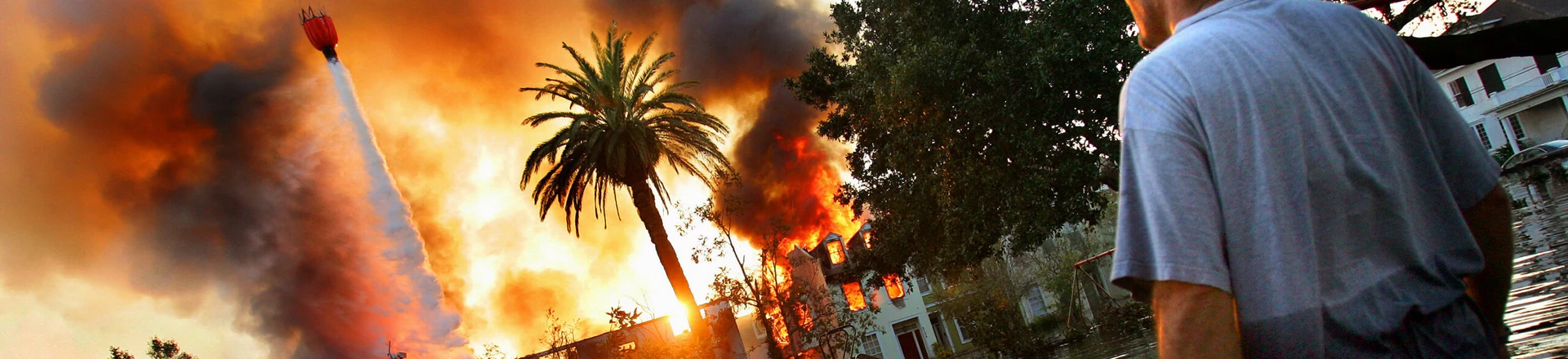 UNITED STATES - SEPTEMBER 04:  A man watches a house burn on Napolean St. as helicopters try to extinguish the fire by dropping water from above in Hurricane Katrina ravaged New Orleans. Because of the extensive flooding caused by the breaking of the city's levies, fire trucks were unable to reach burning homes and in some cases whole blocks burned to the ground.  (Photo by Craig Warga/NY Daily News Archive via Getty Images) UNITED STATES - SEPTEMBER 04:  A man watches a house burn on Napolean St. as helicopters try to extinguish the fire by dropping water from above in Hurricane Katrina ravaged New Orleans. Because of the extensive flooding caused by the breaking of the city's levies, fire trucks were unable to reach burning homes and in some cases whole blocks burned to the ground.  (Photo by Craig Warga/NY Daily News Archive via Getty Images)