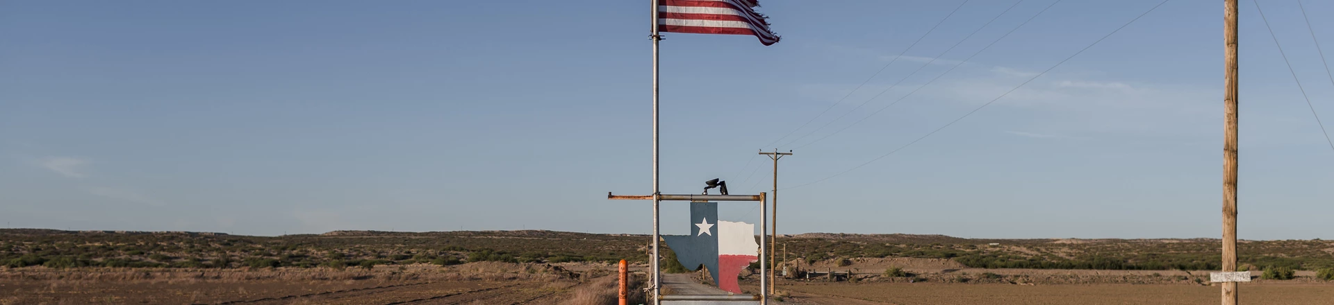Bandeira em propriedade próxima ao muro que marca a fronteira entre os países Estados Unidos e México.