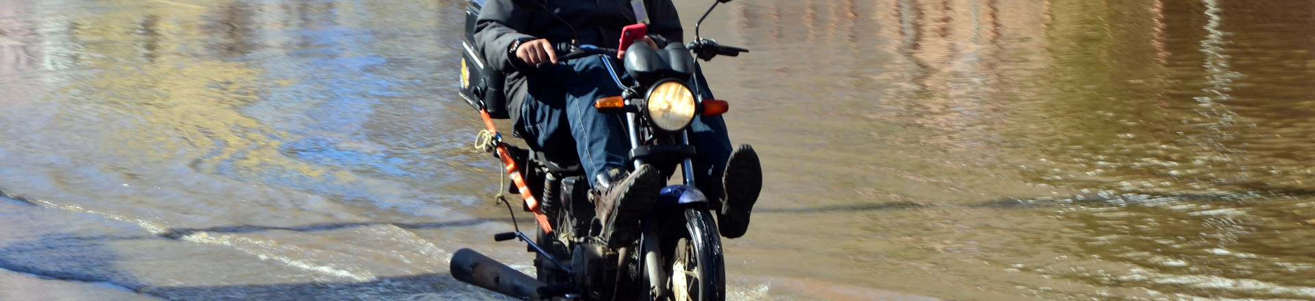 Motoboy em área alagada do Centro de Porto Alegre. Foto: Diego Pires Jonko/Thenews2/Folhapress. Motoboy em área alagada do Centro de Porto Alegre. Foto: Diego Pires Jonko/Thenews2/Folhapress.
