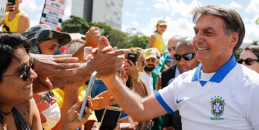O presidente Jair Bolsonaro cumprimenta os apoiadores que se reuniram em frente ao Palácio do Planalto no domingo, dia 15 de março.