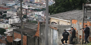 RIO DE JANEIRO, BRAZIL - MARCH 21:  Military Police (PM) conduct an operation in the 'pacified' Complexo do Alemao 'favela' community following a shootout earlier in the day on March 21, 2015 in Rio de Janeiro, Brazil.  The complex of favelas has suffered numerous shootouts recently. The government recently created a commission with the objective to increase social projects in communities such as Complexo do Alemao that have a Pacifying Police Unit (UPP). The new aim acknowledges that the communities, many of which remain plagued by violence and other issues, cannot solely be ?pacified? by police operations.  (Photo by Mario Tama/Getty Images) RIO DE JANEIRO, BRAZIL - MARCH 21:  Military Police (PM) conduct an operation in the 'pacified' Complexo do Alemao 'favela' community following a shootout earlier in the day on March 21, 2015 in Rio de Janeiro, Brazil.  The complex of favelas has suffered numerous shootouts recently. The government recently created a commission with the objective to increase social projects in communities such as Complexo do Alemao that have a Pacifying Police Unit (UPP). The new aim acknowledges that the communities, many of which remain plagued by violence and other issues, cannot solely be ?pacified? by police operations.  (Photo by Mario Tama/Getty Images)