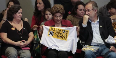 Brazilian suspended President Dilma Rousseff (C) holds a T-shirt reading "Temer out, pro-coup", referring to Brazilian acting President Michel Temer during a rally in Sao Paulo, Brazil on August 23, 2016.Brazil's suspended president Dilma Rousseff enters her final battle to win back power on Thursday, when senators open an impeachment trial expected to remove her from office for good. / AFP / Miguel Schincariol (Photo credit should read MIGUEL SCHINCARIOL/AFP/Getty Images) Brazilian suspended President Dilma Rousseff (C) holds a T-shirt reading "Temer out, pro-coup", referring to Brazilian acting President Michel Temer during a rally in Sao Paulo, Brazil on August 23, 2016.Brazil's suspended president Dilma Rousseff enters her final battle to win back power on Thursday, when senators open an impeachment trial expected to remove her from office for good. / AFP / Miguel Schincariol (Photo credit should read MIGUEL SCHINCARIOL/AFP/Getty Images)
