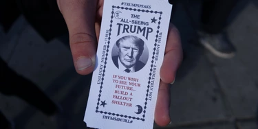 A man hold a card dispensed from the 'All-Seeing Trump', a fortune-telling fairground attraction bearing the likeness of Republican presidential candidate Donald Trump, in New York on October 12, 2016. There's little love for Donald Trump in his hometown these days, so New York has been both tickled and repelled by a fortune-telling, Trump-in-a-box mocking his offense-dishing campaign for president. The Trump-in-a-box has been made to resemble the Zoltar machine made famous in the 1988 Hollywood movie "Big" starring Tom Hanks. / AFP / William EDWARDS (Photo credit should read WILLIAM EDWARDS/AFP/Getty Images)