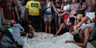 Family members mourn victims from a police operation against drug dealers that occurred on November 19 at Cidade de Deus favela (community) in Rio de Janeiro, Brazil, on November 20, 2016.Rio, which is home to 6.5 million people and drastic social inequality, suffers from high levels of criminality, made worse by heavily armed gangs of narcotraffickers, but also by the presence of paramilitary militias. / AFP / YASUYOSHI CHIBA (Photo credit should read YASUYOSHI CHIBA/AFP/Getty Images)