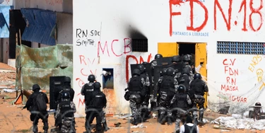 Members of the special police battalion enter the Alcacuz Penitentiary Center to regain control of the penitentiary in Rio Grande do Norte, Brazil, on January 18, 2017.Brazilian authorities said Wednesday they are deploying 1,000 troops to "clean out" arms and cellphones from restive prisons while police struggled to end a deadly gang face-off at Alcacuz. The soldiers were being brought in to respond to a "national emergency" in the badly overcrowded prison system, Defence Minister Raul Jungmann said. / AFP / ANDRESSA ANHOLETE (Photo credit should read ANDRESSA ANHOLETE/AFP/Getty Images) Members of the special police battalion enter the Alcacuz Penitentiary Center to regain control of the penitentiary in Rio Grande do Norte, Brazil, on January 18, 2017.Brazilian authorities said Wednesday they are deploying 1,000 troops to "clean out" arms and cellphones from restive prisons while police struggled to end a deadly gang face-off at Alcacuz. The soldiers were being brought in to respond to a "national emergency" in the badly overcrowded prison system, Defence Minister Raul Jungmann said. / AFP / ANDRESSA ANHOLETE (Photo credit should read ANDRESSA ANHOLETE/AFP/Getty Images)