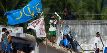Armed and defiant inmates gather on the roofs of the Alcacuz Penitentiary, near Natal, on January 19, 2017.Stick-wielding inmates hurled stones and lit fires Thursday in the jail where dozens were previously massacred, as authorities struggled to contain a spreading wave of gang violence. The governor of the surrounding Rio Grande do Norte state, Robinson Faria, called for the armed forces to deploy in the streets of Natal after rioting spread beyond the prison. / AFP / ANDRESSA ANHOLETE (Photo credit should read ANDRESSA ANHOLETE/AFP/Getty Images) Armed and defiant inmates gather on the roofs of the Alcacuz Penitentiary, near Natal, on January 19, 2017.Stick-wielding inmates hurled stones and lit fires Thursday in the jail where dozens were previously massacred, as authorities struggled to contain a spreading wave of gang violence. The governor of the surrounding Rio Grande do Norte state, Robinson Faria, called for the armed forces to deploy in the streets of Natal after rioting spread beyond the prison. / AFP / ANDRESSA ANHOLETE (Photo credit should read ANDRESSA ANHOLETE/AFP/Getty Images)