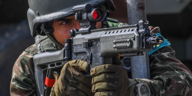 A soldier takes position at the Lins de Vasconcelos slum complex during a crackdown on crime gangs in Rio de Janeiro, Brazil, on August 5, 2017.Thousands of Brazilian army troops raided Rio de Janeiro slums leaving parts of the city looking like a war zone. Their main goal was to stop gangs behind a surge in brazen robberies of commercial trucks, with arrest warrants issued for 40 people. However, the unusually aggressive pre-dawn operation also follows wider concerns that nearly bankrupt post-Olympic Rio is spinning out of control. / AFP PHOTO / Apu Gomes (Photo credit should read APU GOMES/AFP/Getty Images)