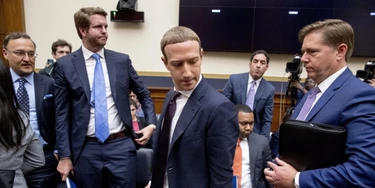 O CEO do Facebook, Mark Zuckerberg, ao centro, acompanhado pelo vice-presidente de políticas públicas dos EUA, Kevin Martin, à direita, faz uma pausa nos depoimentos antes de uma audiência do Comitê de Serviços Financeiros da Câmara em Washington, D.C., em 23 de outubro de 2019.