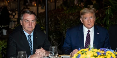 FILE - In this March 7, 2020, file photo President Donald Trump is seated before a dinner with Brazilian President Jair Bolsonaro, left, at Mar-a-Lago in Palm Beach, Fla. Bolsonaro’s communications director, Fábio Wajngarten, tested positive just days after traveling with Bolsonaro to a meeting with Trump and senior aides in Florida. (AP Photo/Alex Brandon, File)