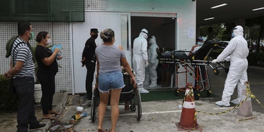 In this April 16, 2020 photo, Jonas Sena, suspected of suffering from COVID-19 disease, waits on a stretcher to be allowed in the 28 de Agosto hospital in Manaus, Amazonas state, Brazil. Manaus’ health care system, already strained before the coronavirus crisis, is buckling under the current onslaught of coronavirus patients. (AP Photo/Edmar Barros) In this April 16, 2020 photo, Jonas Sena, suspected of suffering from COVID-19 disease, waits on a stretcher to be allowed in the 28 de Agosto hospital in Manaus, Amazonas state, Brazil. Manaus’ health care system, already strained before the coronavirus crisis, is buckling under the current onslaught of coronavirus patients. (AP Photo/Edmar Barros)