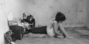 Migrante de 10 anos, que fugiu de ameaças de gangues de El Salvador, senta-se sobre os lençóis que sua família usa como cama em uma casa alugada em Tapachula, Chiapas.