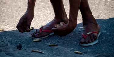 A resident of the Complex do Alemao favela collects cases on Itaoca Avenue as Rio de Janeiro's Military Police Special Unit (Choque) carries out an operation at the slum, in Rio, Brazil, on July 16, 2018. (Photo by Mauro PIMENTEL / AFP)        (Photo credit should read MAURO PIMENTEL/AFP via Getty Images) A resident of the Complex do Alemao favela collects cases on Itaoca Avenue as Rio de Janeiro's Military Police Special Unit (Choque) carries out an operation at the slum, in Rio, Brazil, on July 16, 2018. (Photo by Mauro PIMENTEL / AFP)        (Photo credit should read MAURO PIMENTEL/AFP via Getty Images)