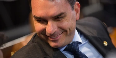 Senator Flavio Bolsonaro, a Social Liberal Party (PSL) member for Rio de Janeiro state, smiles during a confirmation hearing for Roberto Campos Neto, president of the Central Bank of Brazil nominee for Brazilian President Jair Bolsonaro, not pictured, in Brasilia, Brazil, on Tuesday, Feb. 26, 2019. Campos Neto in his initial remarks ticked off several boxes on the investor wish list, such as reaffirming the need for fiscal discipline, inflation control, and central bank autonomy. Photographer: Andre Coelho/Bloomberg via Getty Images Senator Flavio Bolsonaro, a Social Liberal Party (PSL) member for Rio de Janeiro state, smiles during a confirmation hearing for Roberto Campos Neto, president of the Central Bank of Brazil nominee for Brazilian President Jair Bolsonaro, not pictured, in Brasilia, Brazil, on Tuesday, Feb. 26, 2019. Campos Neto in his initial remarks ticked off several boxes on the investor wish list, such as reaffirming the need for fiscal discipline, inflation control, and central bank autonomy. Photographer: Andre Coelho/Bloomberg via Getty Images