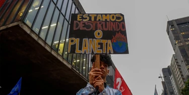 A man holds a sing that reads "We are destroying the planet" during a protest along Paulista Avenue in Sao Paulo, Brazil, on September 20, 2019, in the framework of the "Friday for the planet" global demo against climate change. A man holds a sing that reads "We are destroying the planet" during a protest along Paulista Avenue in Sao Paulo, Brazil, on September 20, 2019, in the framework of the "Friday for the planet" global demo against climate change.