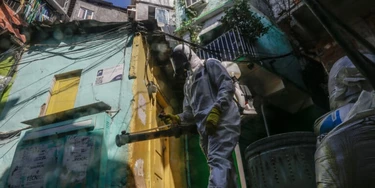 A worker wearing personal protective equipment (PPE) performs disinfection operations at Dona Marta favela in Rio de Janeiro, Brazil, on Saturday, March 27, 2021. Staggering under its worst period of the pandemic, with daily records of caseloads and deaths, Brazil is facing a daunting development: a rising number of deaths among the young. Photographer: Andre Coelho/Bloomberg via Getty Images