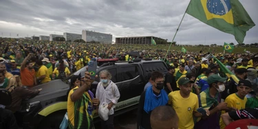 BRASILIA, BRAZIL - JANUARY 08: Supporters of former President Jair Bolsonaro clash with security forces as they raid the National Congress in Brasilia, Brazil, 08 January 2023. Groups shouting slogans demanding intervention from the army broke through the police barrier and entered the Congress building, according to local media. Police intervened with tear gas to disperse pro-Bolsonaro protesters. Some demonstrators were seen climbing onto the roofs of the House of Representatives and Senate buildings. (Photo by Joedson Alves/Anadolu Agency via Getty Images)