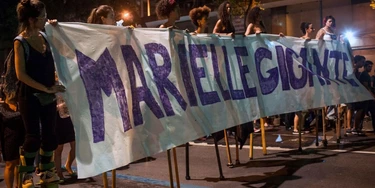 A group of women on stilts hold a banner reading "Giant Marielle" during a protest against the murder of Brazilian councilwoman and activist Marielle Franco in Rio de Janeiro, Brazil on March 15, 2018. Brazilians mourned for the Rio de Janeiro councilwoman and outspoken critic of police brutality who was shot in the city center in an assassination-style killing on the eve. / AFP PHOTO / Mauro Pimentel (Photo credit should read MAURO PIMENTEL/AFP/Getty Images) A group of women on stilts hold a banner reading "Giant Marielle" during a protest against the murder of Brazilian councilwoman and activist Marielle Franco in Rio de Janeiro, Brazil on March 15, 2018. Brazilians mourned for the Rio de Janeiro councilwoman and outspoken critic of police brutality who was shot in the city center in an assassination-style killing on the eve. / AFP PHOTO / Mauro Pimentel (Photo credit should read MAURO PIMENTEL/AFP/Getty Images)