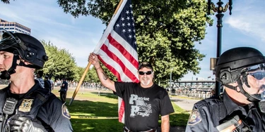 Policiais ao lado de um participante de uma manifestação pela liberdade de expressão organizada pelo grupo de extrema-direita Patriot Prayer em Portland, nos EUA, no dia 10 de setembro de 2017. Policiais ao lado de um participante de uma manifestação pela liberdade de expressão organizada pelo grupo de extrema-direita Patriot Prayer em Portland, nos EUA, no dia 10 de setembro de 2017.