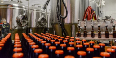 LONDON, ENGLAND - DECEMBER 08:  A batch of bottled Megawatt Double I.P.A. lies in front of the fermenting vessels at inner city craft beer makers Brixton Brewery on December 8, 2015 in London, England. Located in three railway arches on Brixton Station Road, the Brixton Brewery was founded in 2013 by two local couples and hand craft nine varieties of beer in small batches. The brewery has expanded into a third railway arch at the end of 2015 as the business grows.  (Photo by Chris Ratcliffe/Getty Images)