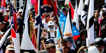 White nationalist demonstrators walk into the entrance of Lee Park surrounded by counter demonstrators in Charlottesville, Va., Saturday, Aug. 12, 2017. Gov. Terry McAuliffe declared a state of emergency and police dressed in riot gear ordered people to disperse after chaotic violent clashes between white nationalists and counter protestors. (AP Photo/Steve Helber) White nationalist demonstrators walk into the entrance of Lee Park surrounded by counter demonstrators in Charlottesville, Va., Saturday, Aug. 12, 2017. Gov. Terry McAuliffe declared a state of emergency and police dressed in riot gear ordered people to disperse after chaotic violent clashes between white nationalists and counter protestors. (AP Photo/Steve Helber)