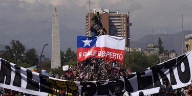 Manifestantes exibem cartaz "Chile acorda" no quinto dia de protestos na capital Santiago.  Manifestantes exibem cartaz "Chile acorda" no quinto dia de protestos na capital Santiago.