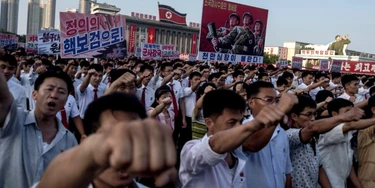 People wave banners and shout slogans as they attend a rally in support of North Korea's stance against the US, on Kim Il-Sung square in Pyongyang on August 9, 2017.
US President Donald Trump said the United States' nuclear arsenal was "more powerful than ever" in a fresh warning to North Korea over its repeated missile tests. / AFP PHOTO / KIM Won-Jin (Photo credit should read KIM WON-JIN/AFP/Getty Images) People wave banners and shout slogans as they attend a rally in support of North Korea's stance against the US, on Kim Il-Sung square in Pyongyang on August 9, 2017.
US President Donald Trump said the United States' nuclear arsenal was "more powerful than ever" in a fresh warning to North Korea over its repeated missile tests. / AFP PHOTO / KIM Won-Jin (Photo credit should read KIM WON-JIN/AFP/Getty Images)
