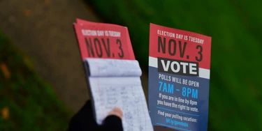 Caleb Malchik, 27, segura panfletos que informam o dia da votação, em campanha do sindicato Unite Here para Joe Biden, em 1º de novembro de 2020, em Landsdowne, Pensilvânia.  Caleb Malchik, 27, segura panfletos que informam o dia da votação, em campanha do sindicato Unite Here para Joe Biden, em 1º de novembro de 2020, em Landsdowne, Pensilvânia.