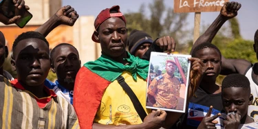 Manifestantes reunidos em Ouagadougou, capital da Burkina Faso, para demonstrar apoio aos militares, seguram uma fotografia do tenente-coronel Paul-Henri Sandaogo Damiba, em 25 de janeiro de 2022.