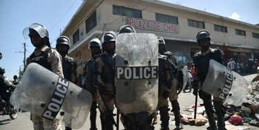 Police watch as demonstrators march to protest against the government of Haitian President Jovenel Moise in Port-au-Prince October 24, 2017. / AFP PHOTO / HECTOR RETAMAL (Photo credit should read HECTOR RETAMAL/AFP/Getty Images) Police watch as demonstrators march to protest against the government of Haitian President Jovenel Moise in Port-au-Prince October 24, 2017. / AFP PHOTO / HECTOR RETAMAL (Photo credit should read HECTOR RETAMAL/AFP/Getty Images)