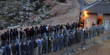 NI'ILIN, WEST BANK - JANUARY 03:  Palestinian labourers line up to cross an Israeli checkpoint as they return to their homes after a day's work in the Jewish state on January 3, 2010 near the village of Ni'ilin in the West Bank. Palestinians complain that the thousands of workers who have been granted coveted Israeli work permits find themselves waiting for hours without shelter and in all kinds of weather to cross the military checkpoints, leaving home hours before sunrise and returning late in the evening because of delays at the crossings.  (Photo by David Silverman/Getty Images)