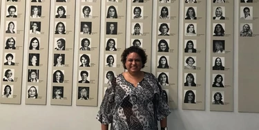 Lola Aronovich em frente a um mural com fotos de deputadas mulheres no Congresso Nacional, em Brasília.