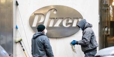 Trabalhadores limpam o logotipo da Pfizer em 21 de dezembro de 2020, em Nova York. Trabalhadores limpam o logotipo da Pfizer em 21 de dezembro de 2020, em Nova York.