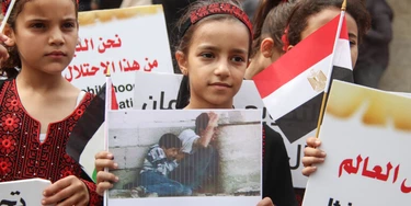 Crianças palestinas participam de protesto contra o cerco israelita à Faixa de Gaza, no Dia da Criança Árabe, em frente à sede do Programa das Nações Unidas para o Desenvolvimento (PNUD).