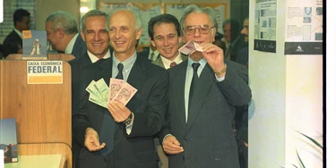 Em 1994, o ministro da Fazenda, Rubens Ricupero, e o presidente Itamar Franco mostram as cédulas de reais após troca das notas de cruzeiros reais em agência da Caixa Econômica Federal no Palácio do Planalto, em Brasília. (Brasília, DF, 01.07.1994. Foto de Sérgio Lima/Folhapress) Em 1994, o ministro da Fazenda, Rubens Ricupero, e o presidente Itamar Franco mostram as cédulas de reais após troca das notas de cruzeiros reais em agência da Caixa Econômica Federal no Palácio do Planalto, em Brasília. (Brasília, DF, 01.07.1994. Foto de Sérgio Lima/Folhapress)