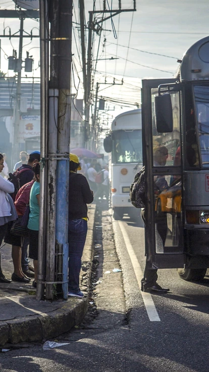Passageiros fazem fila para embarcar em um ônibus em San Salvador, em 19 de julho de 2022. A aposta de El Salvador no bitcoin está exacerbando a crise da dívida do país.