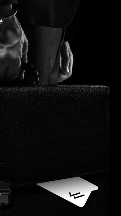 side view of businessman in handcuffs holding briefcase isolated on black