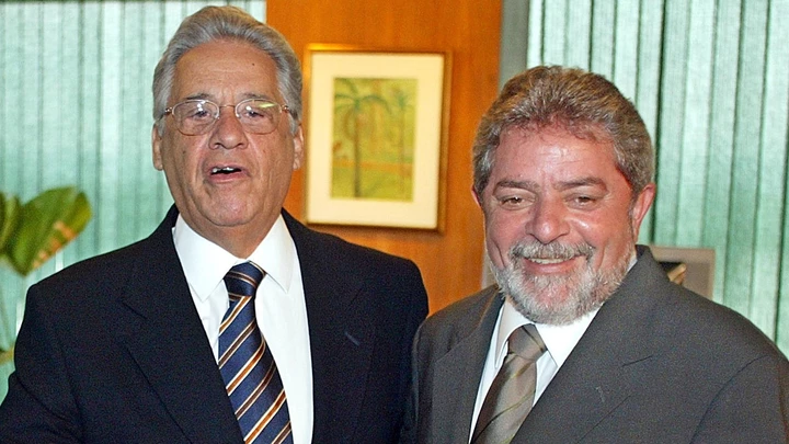 Brazilian newly elected president Luiz Inacio Lula da Silva (R) smiles as ruling president Fernando Henrique Cardoso jokes with the photographers, 29 October 2002, during a meeting at the presidential Palace in Brazilia, Brazil. Lula da Silva was elected with some 53 millions vote last 27 October, and will starts his governement period on January 2003.    AFP  PHOTO  Antonio SCORZA (Photo credit should read ANTONIO SCORZA/AFP/Getty Images)