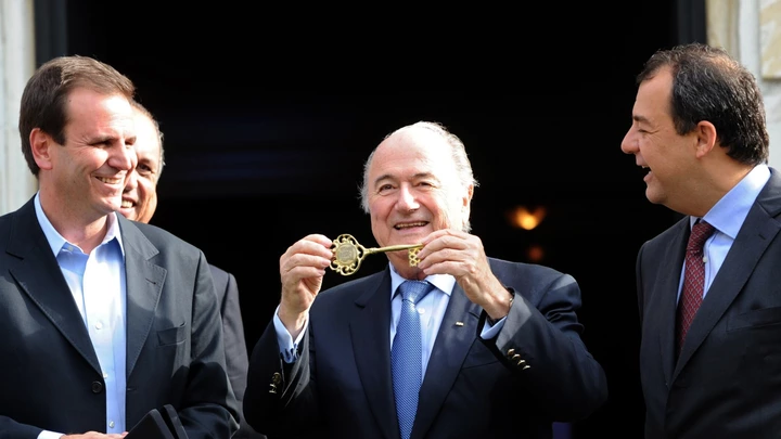 FIFA's President Joseph S. Blatter (C) shows the Rio de Janeiro City key next to Rio de Janeiro's Major Eduardo Paes (L) and Rio de Janeiro's Governor Sergio Cabral at the City Palace in Rio de Janeiro, Brazil, on July 29, 2011. Blatter is in Rio de Janeiro to take part in the Preliminary draw for the FIFA World Cup 2014 which will be held on Saturday. AFP PHOTO/Evaristo SA (Photo credit should read EVARISTO SA/AFP/Getty Images)
