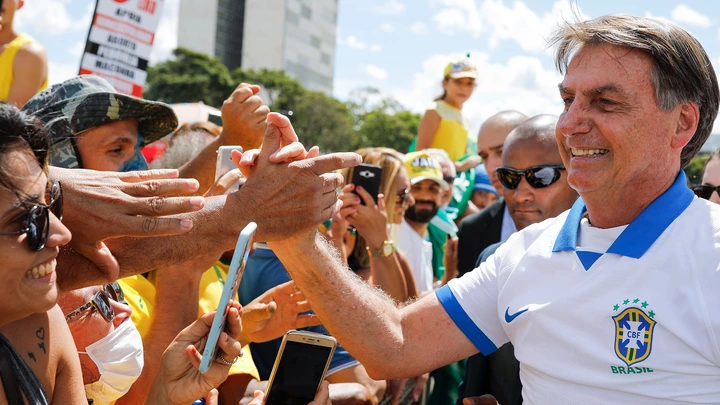O presidente Jair Bolsonaro cumprimenta os apoiadores que se reuniram em frente ao Palácio do Planalto no domingo, dia 15 de março.