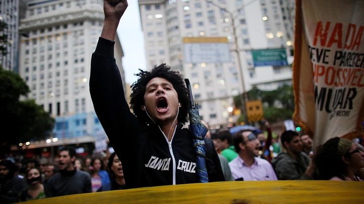 RIO DE JANEIRO, BRAZIL - OCTOBER 31: Anti-government protesters march through the Centro district on October 31, 2013 in Rio de Janeiro, Brazil. Protesters called for an end to police violence and corruption and voiced demands for better public services. (Photo by Mario Tama/Getty Images)