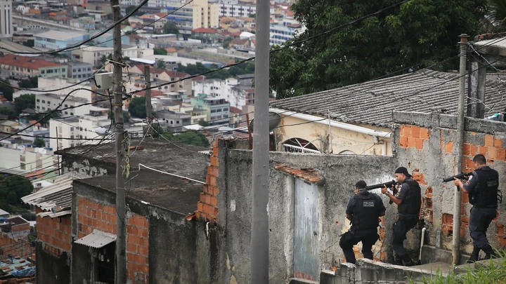 RIO DE JANEIRO, BRAZIL - MARCH 21:  Military Police (PM) conduct an operation in the 'pacified' Complexo do Alemao 'favela' community following a shootout earlier in the day on March 21, 2015 in Rio de Janeiro, Brazil.  The complex of favelas has suffered numerous shootouts recently. The government recently created a commission with the objective to increase social projects in communities such as Complexo do Alemao that have a Pacifying Police Unit (UPP). The new aim acknowledges that the communities, many of which remain plagued by violence and other issues, cannot solely be ?pacified? by police operations.  (Photo by Mario Tama/Getty Images)