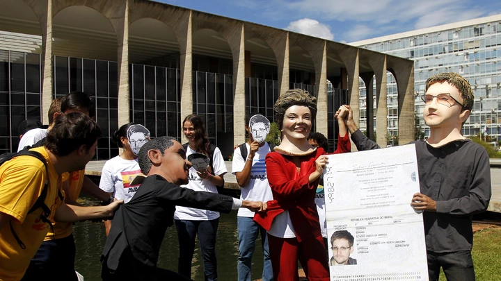 Members of the Avaaz online community organization stage in front of the Itamaraty Forein Ministry Palace the delivery of the Brazilian passport by Brazilian President Dilma Rousseff to Edward Snowden while U.S. President Barack Obama tries to stop her, in Brasilia, on February 13, 2014. Avaaz members have collected over a million signatures in favor of the asylum application for Snowden, the former CIA technician  that disclosed the spying by the U.S. government to millions of people, among whom President Rousseff and German Chancellor Angela Merkel. AFP PHOTO/Beto BARATA        (Photo credit should read BETO BARATA/AFP/Getty Images) Members of the Avaaz online community organization stage in front of the Itamaraty Forein Ministry Palace the delivery of the Brazilian passport by Brazilian President Dilma Rousseff to Edward Snowden while U.S. President Barack Obama tries to stop her, in Brasilia, on February 13, 2014. Avaaz members have collected over a million signatures in favor of the asylum application for Snowden, the former CIA technician  that disclosed the spying by the U.S. government to millions of people, among whom President Rousseff and German Chancellor Angela Merkel. AFP PHOTO/Beto BARATA        (Photo credit should read BETO BARATA/AFP/Getty Images)