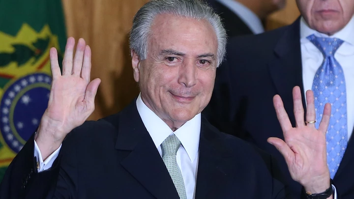 BRASILIA, BRAZIL - MAY 12:  Brazil's interim President Michel Temer waves at a signing ceremony for new government ministers at the Planalto presidential palace after the Senate voted to accept impeachment charges against suspended President Dilma Rousseff on May 12, 2016 in Brasilia, Brazil. Rousseff has been suspended from her presidential duties and will face a Senate trial for alleged manipulation of government accounts.  (Photo by Mario Tama/Getty Images)