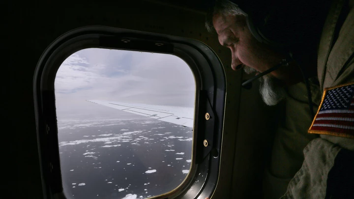 Lyn Lohberger of NASA looks out as sea ice floats near the coast of West Antarctica from a window of a NASA Operation IceBridge airplane on October 27, 2016 in-flight over Antarctica. NASA's Operation IceBridge has been studying how polar ice has evolved over the past eight years. Researchers have used the IceBridge data to observe that the West Antarctic Ice Sheet may be in a state of irreversible decline directly contributing to rising sea levels. 