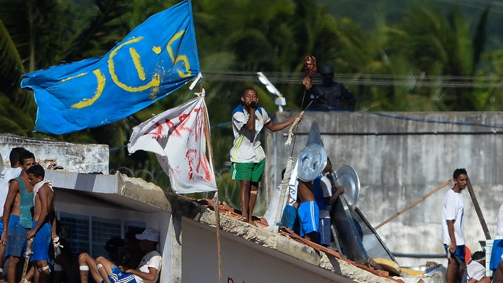 Armed and defiant inmates gather on the roofs of the Alcacuz Penitentiary, near Natal, on January 19, 2017.Stick-wielding inmates hurled stones and lit fires Thursday in the jail where dozens were previously massacred, as authorities struggled to contain a spreading wave of gang violence. The governor of the surrounding Rio Grande do Norte state, Robinson Faria, called for the armed forces to deploy in the streets of Natal after rioting spread beyond the prison. / AFP / ANDRESSA ANHOLETE (Photo credit should read ANDRESSA ANHOLETE/AFP/Getty Images) Armed and defiant inmates gather on the roofs of the Alcacuz Penitentiary, near Natal, on January 19, 2017.Stick-wielding inmates hurled stones and lit fires Thursday in the jail where dozens were previously massacred, as authorities struggled to contain a spreading wave of gang violence. The governor of the surrounding Rio Grande do Norte state, Robinson Faria, called for the armed forces to deploy in the streets of Natal after rioting spread beyond the prison. / AFP / ANDRESSA ANHOLETE (Photo credit should read ANDRESSA ANHOLETE/AFP/Getty Images)