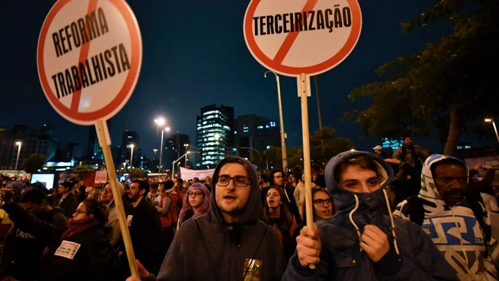 Demonstrators take part in a national strike against a labour and social welfare reform bill that the government of President Michel Temer intends to pass, in Sao Paulo, Brazil, on April 28, 2017.Major transportation networks schools and banks were partially shut down across much of Brazil on Friday in what protesters called a general strike against austerity reforms in Latin America's biggest country. / AFP PHOTO / NELSON ALMEIDA (Photo credit should read NELSON ALMEIDA/AFP/Getty Images)