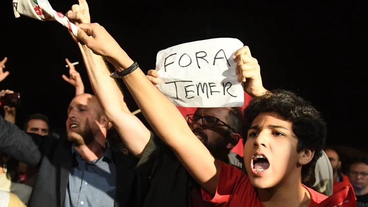 Demonstrators protest against Brazilian President Michel Temer outside the Planalto Palace in Brasilia on May 17, 2017.Temer was secretly taped by one of the owners of J&F Investimentos - the family holding company that controls the JBS meat processing company - giving the green light to a bribery scheme to keep Cunha quiet, the Brazilian newspaper O Globo reported on May 17, 2017. / AFP PHOTO / EVARISTO SA (Photo credit should read EVARISTO SA/AFP/Getty Images)