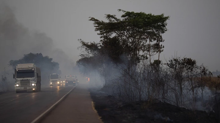 Caminhões dirigem ao lado de campos queimados na rodovia BR-163, no estado do Mato Grosso, em 23 de agosto de 2019.