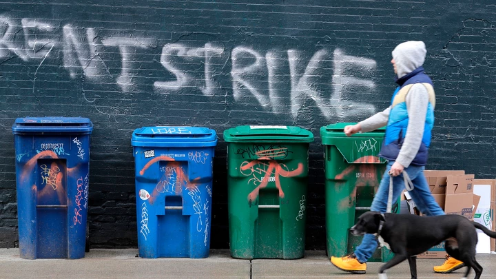 Um pedestre passa por um grafite que diz "Greve de Aluguéis" em 1 de abril de 2020, no bairro de Capitol Hill, em Seattle.