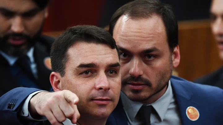 Brazilian Senator for Rio de Janeiro Flavio Bolsonaro (L) and Councillor of Rio de Janeiro Carlos Bolsonaro attend their father Brazilian President-elect Jair Bolsonaro's ceremony to receive a diploma that certifies he can take office as president, at the TSE in Brasilia, on December 10, 2018. - Bolsonaro takes office on January 1, 2019. (Photo by EVARISTO SA / AFP)        (Photo credit should read EVARISTO SA/AFP/Getty Images) Brazilian Senator for Rio de Janeiro Flavio Bolsonaro (L) and Councillor of Rio de Janeiro Carlos Bolsonaro attend their father Brazilian President-elect Jair Bolsonaro's ceremony to receive a diploma that certifies he can take office as president, at the TSE in Brasilia, on December 10, 2018. - Bolsonaro takes office on January 1, 2019. (Photo by EVARISTO SA / AFP)        (Photo credit should read EVARISTO SA/AFP/Getty Images)